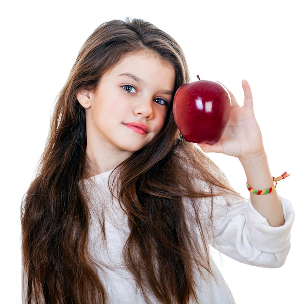 Photo portrait d'une belle petite fille tenant une pomme rouge isolée sur un fond blanc