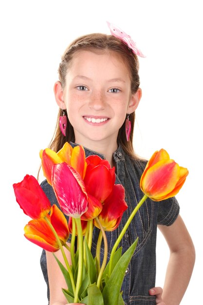 Portrait de belle petite fille avec des tulipes d'isolement sur le blanc