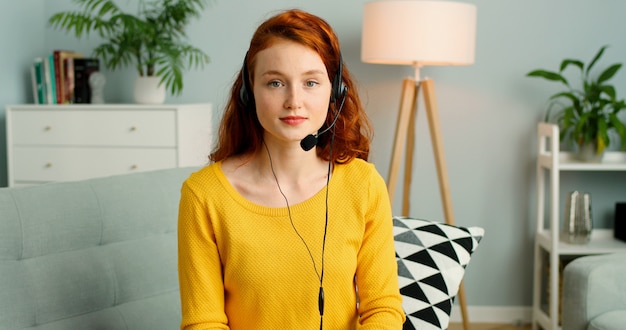 Portrait de la belle rousse avec des casques d'écoute