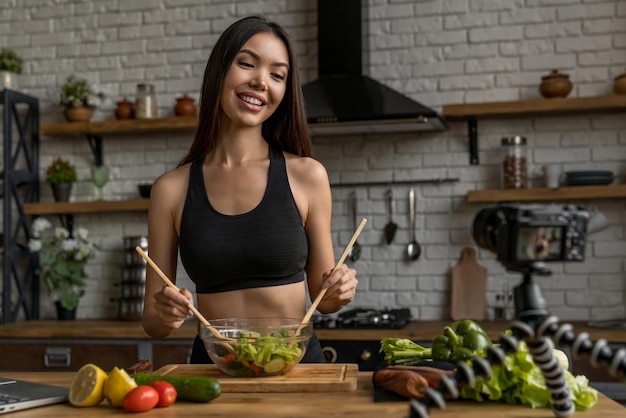 Portrait d'une blogueuse influenceuse asiatique examinant une salade et enregistrant une vidéo pour son vlog