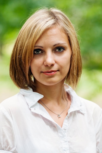 Portrait d'une blonde dans un parc d'été libre