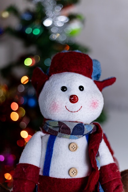 Portrait de bonhomme de neige en peluche avec des lumières de Noël