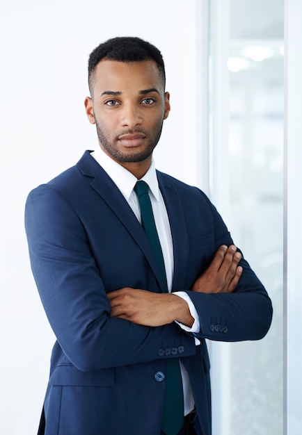 Portrait de bras croisés et d'un homme noir au bureau avec un costume pour une carrière d'entreprise, un emploi ou une fierté, un visage d'affaires et d'entrepreneur professionnel confiant, un travailleur et un agent d'assurance sur le lieu de travail au Nigeria.