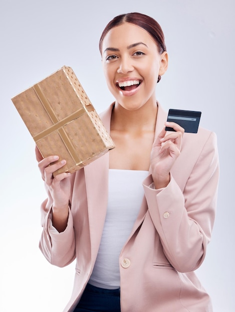Portrait de cadeau et femme heureuse avec carte de crédit en studio wow et sourire pour cadeau de remboursement sur fond gris Récompense du client et visage féminin avec boîte présent promotion pour la vente au détail ou le paiement