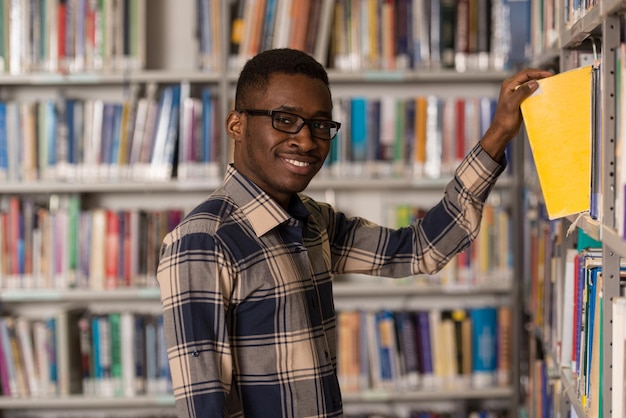 a, portrait, de, une, caucasien, étudiant collégial, homme, dans, bibliothèque, faible profondeur champ