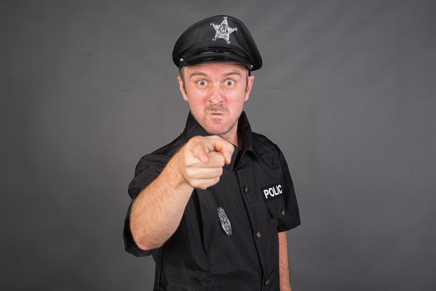 portrait, de, caucasien, homme, porter, uniforme police, déguisement, doigt pointé, appareil-photo