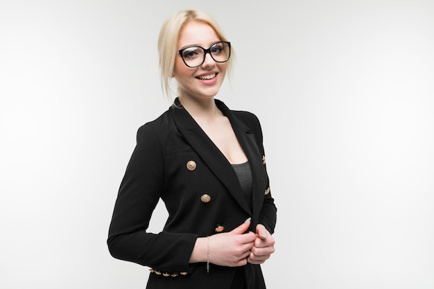 Portrait d'une charmante blonde en costume noir possédant des lunettes