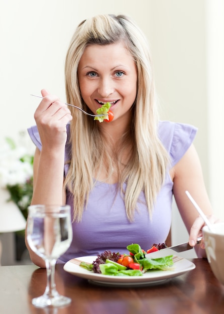 Portrait d&#39;une charmante femme mangeant une salade