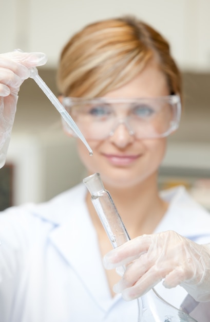 Portrait d&#39;une charmante femme scientifique à l&#39;aide d&#39;une pipette