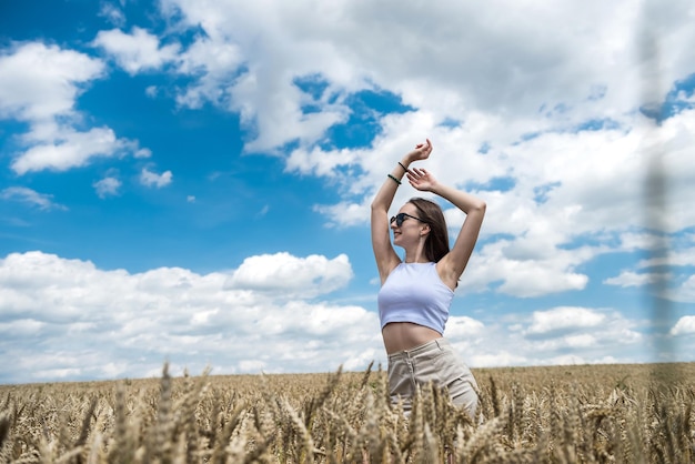 Portrait de charmante jeune femme en liberté de champ de céréales dorées