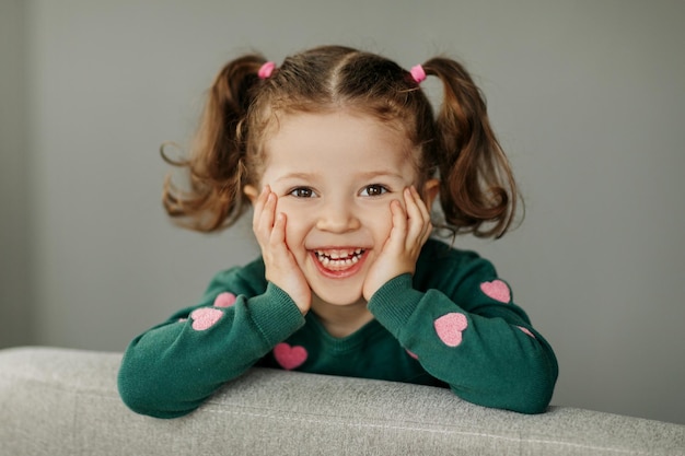 Portrait d'une charmante petite fille avec deux queues de cheval joyeuse et souriante