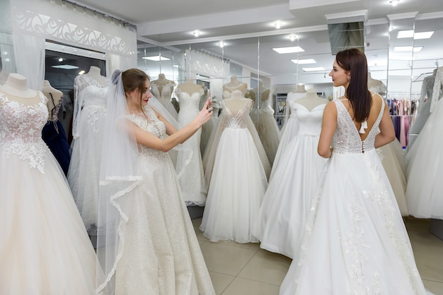 Portrait de charmantes jeunes femmes portant des robes blanches dans le salon de la mariée