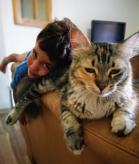 Photo portrait d'un chat et d'un garçon à la maison