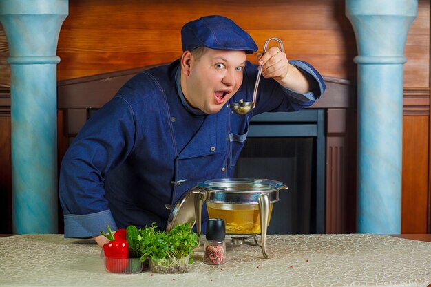 Portrait de chef avec une louche dans la main.