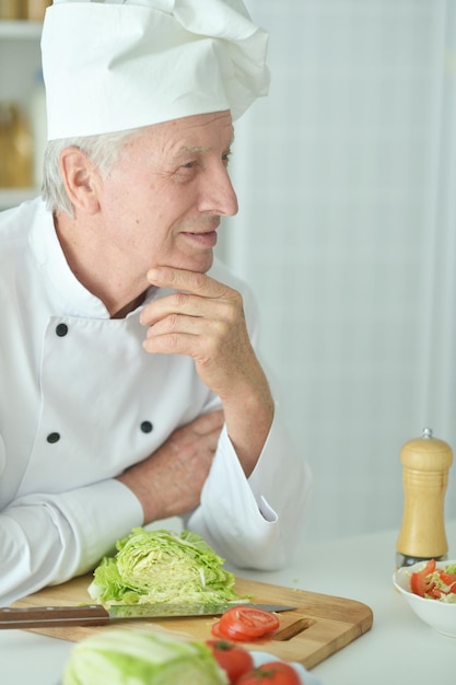 Portrait d'un chef masculin âgé cuisinant à la cuisine