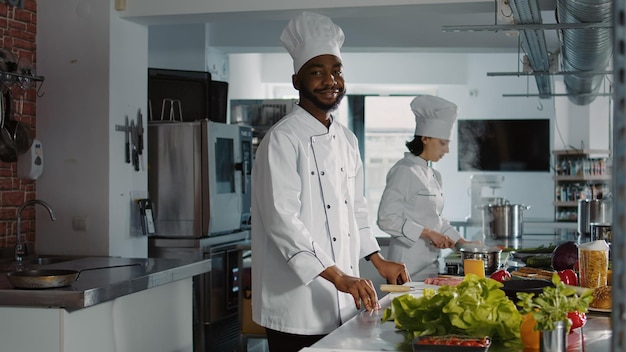 Portrait d'un chef souriant dans une cuisine commerciale