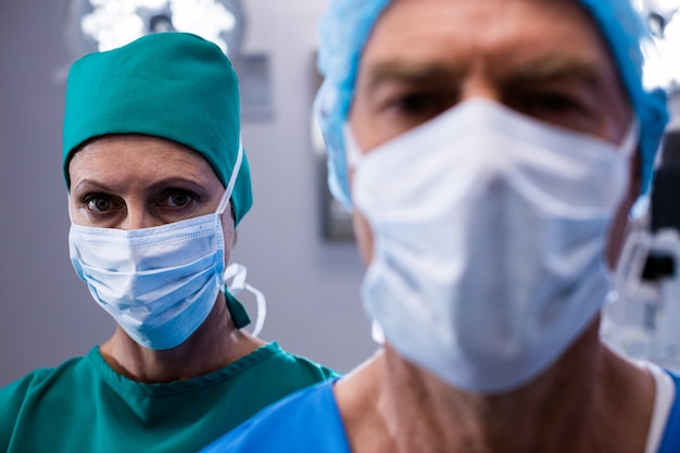 Portrait de chirurgiens portant un masque chirurgical en salle d'opération