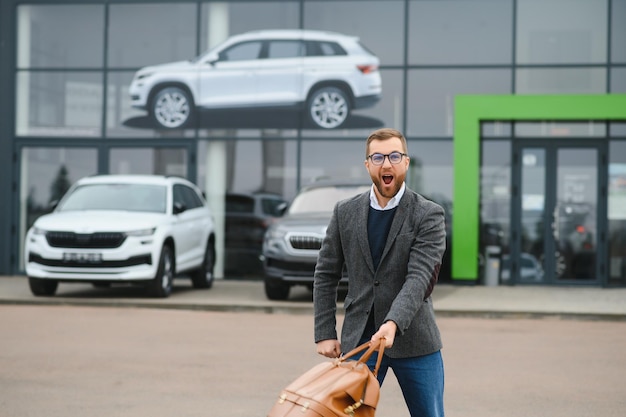 Portrait d'un client heureux achetant une nouvelle voiture