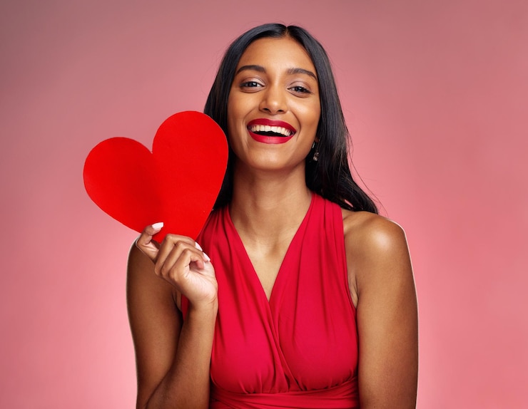 Photo portrait coeur et médias sociaux avec une femme sur fond rose en studio pour l'amour ou la romance sourire emoji et saint valentin avec une jeune femme heureuse tenant une forme ou un symbole d'affection