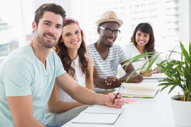 Portrait de collègues souriants assis au bureau