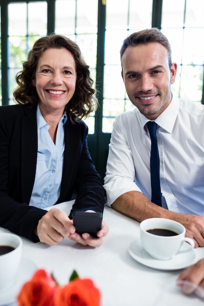 Portrait de collègues de travail avec téléphone portable