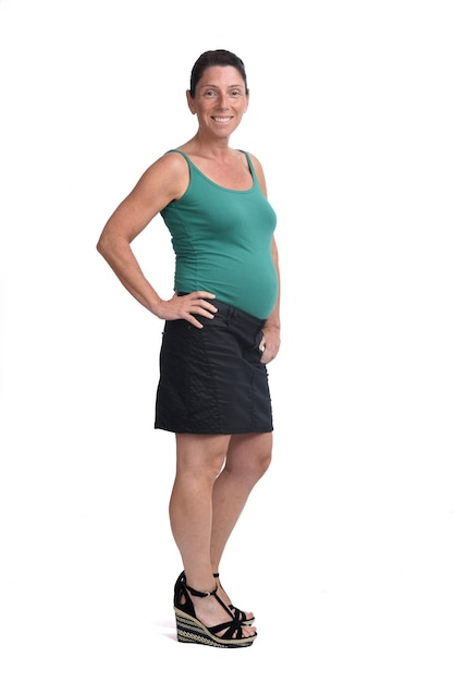 Portrait complet d'une femme enceinte avec une jupe sur fond blanc,