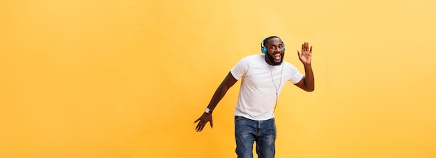 Portrait complet d'un jeune homme afro-américain cerise écoutant de la musique avec des écouteurs et d
