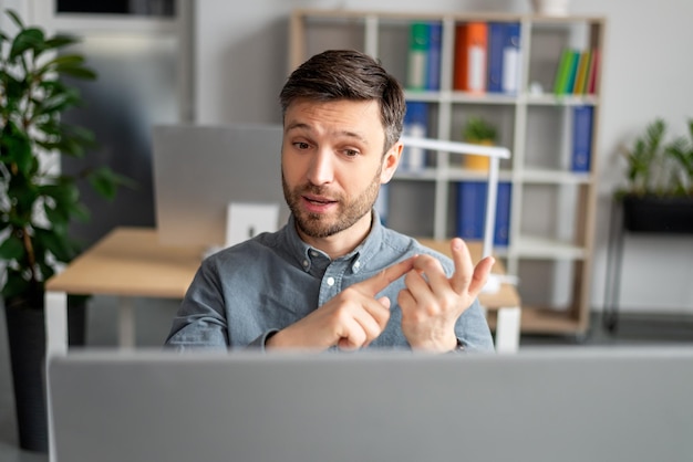 Portrait de concept de réunion virtuelle d'un chef d'entreprise mature ayant parlé à l'aide d'un ordinateur sur le lieu de travail