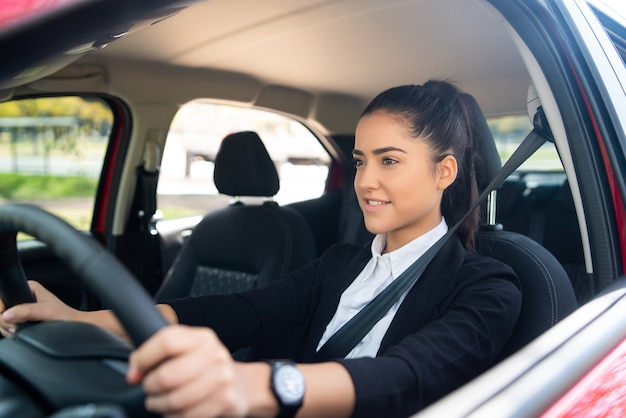 Portrait de conductrice professionnelle au volant de sa voiture. Concept de transport.