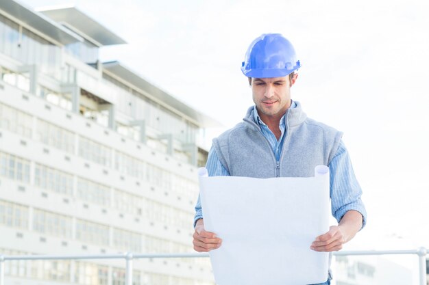 Portrait, confiant, architecte, lecture, blueprint, dehors, bâtiment