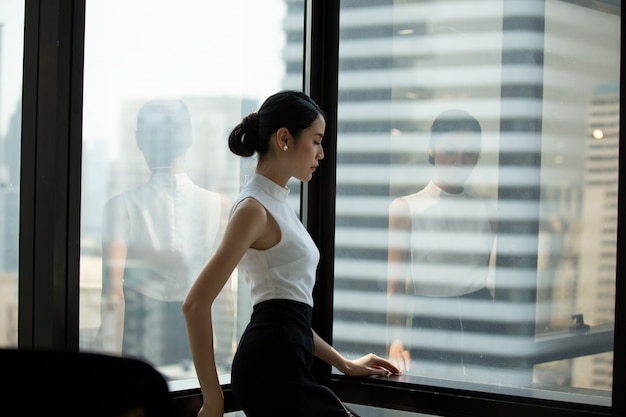 portrait, confiant, femmes affaires, debout, fenêtre, bureau