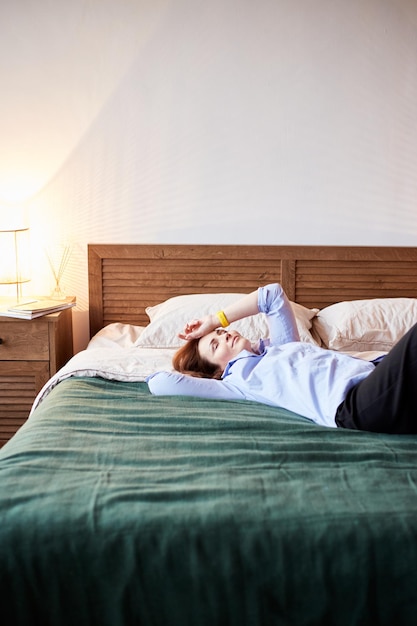 Portrait confortable d'une femme du millénaire se reposant sur un lit douillet Chambre à coucher avec un intérieur moderne