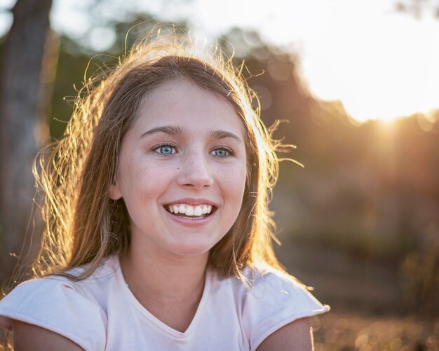 Photo portrait de contre-jour d'une jeune fille heureuse