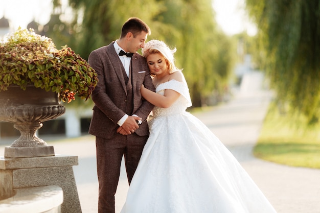 Portrait de corps pleine longueur de jeune mariée et le marié qui court sur l'herbe verte du terrain de golf. Couple de mariage heureux marchant dans le parcours de golf, espace copie