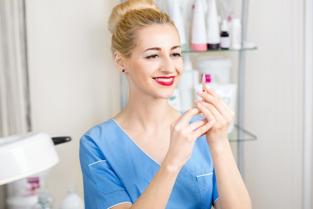 Portrait de cosmétologue avec seringue dans le bureau de cosmétologie