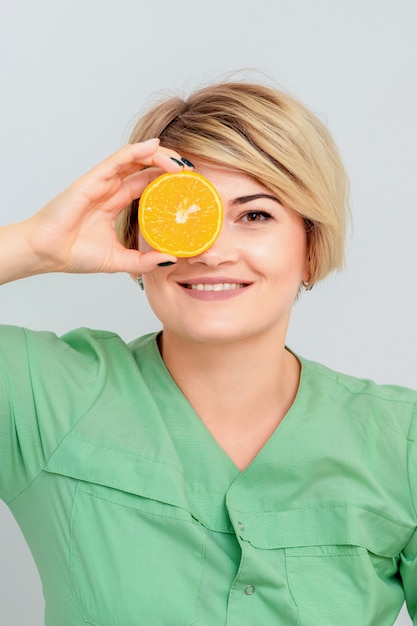 Portrait de cosmétologue avec une tranche d'orange.
