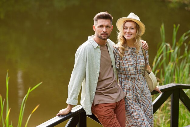 Portrait De Couple Adulte Romantique Tout En Posant Au Bord Du Lac à L'extérieur Dans Un Décor Rustique