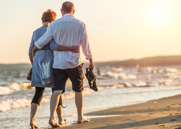 Portrait d'un couple d'adultes âgés étreignant le long de la côte de la mer