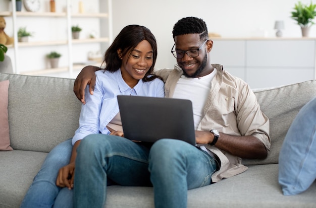 Portrait d'un couple afro-américain utilisant un ordinateur portable à la maison