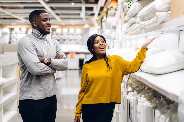 Portrait d'un couple d'amoureux afro-américain souriant parlant et marchant faisant du shopping vente et achats à la recherche de choisir d'acheter quelque chose en vacances au concept de mode de vie de vente de magasin