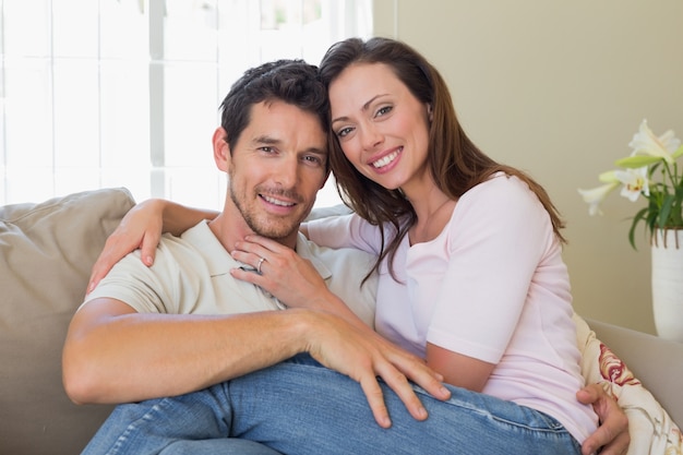 Portrait d&#39;un couple d&#39;amoureux assis sur le canapé