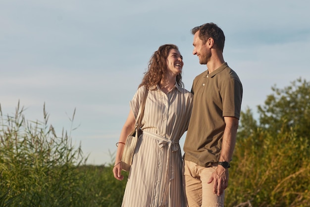 Photo portrait d'un couple d'amoureux dans la nature contre l'espace de copie de ciel bleu