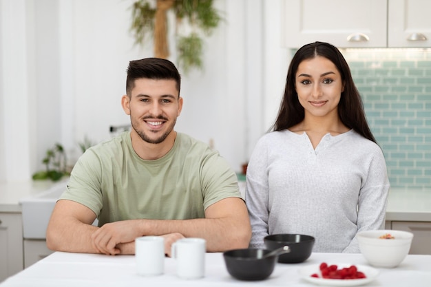 Portrait d'un couple d'amoureux heureux prenant son petit déjeuner ensemble dans la cuisine