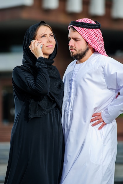 Portrait de couple arabe habillé yang jouer avec téléphone mobile.