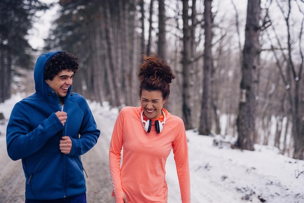 Portrait d'un couple athlétique s'amusant pendant l'hiver dans la forêt