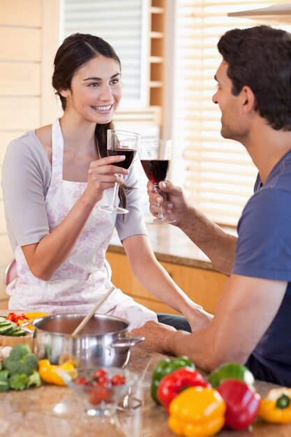 Portrait d&#39;un couple ayant un verre de vin pendant la cuisson