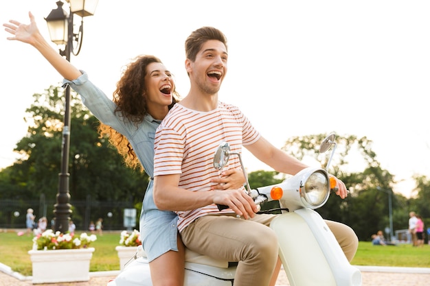 Portrait de couple européen, à moto ensemble à travers la rue de la ville