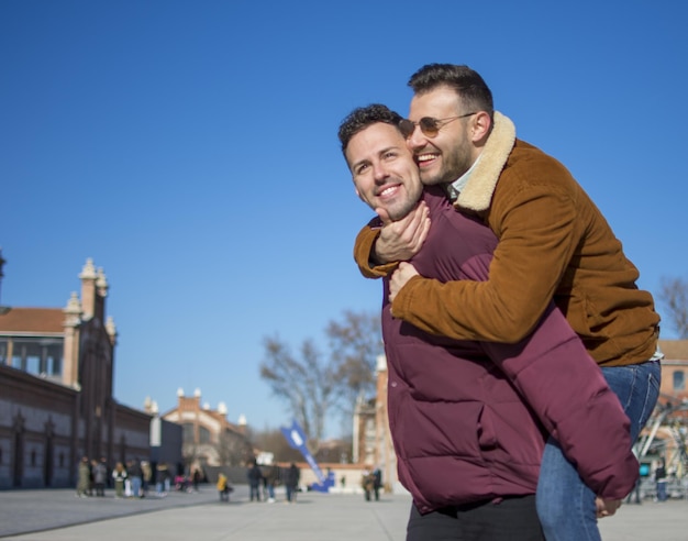 Un portrait d'un couple gay heureux à l'extérieur par une journée ensoleillée