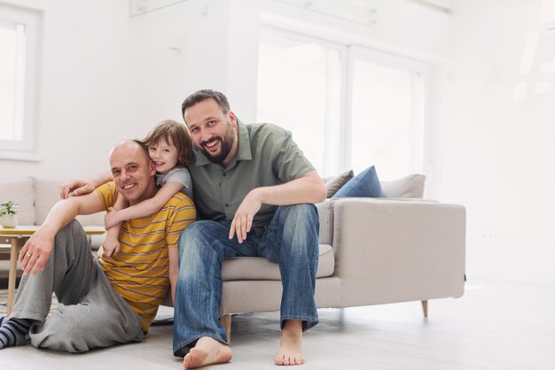 Portrait d'un couple gay masculin avec des enfants adoptés petite fille tout en s'amusant à la maison