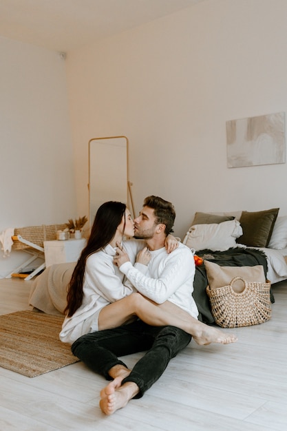 Portrait d'un couple heureux amoureux étreindre assis à la maison